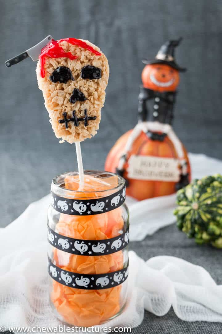 Skull-shaped Halloween Rice Krispie Treats standing vertically on a treat stick.