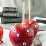 A candy apple covered with candy eyeballs.